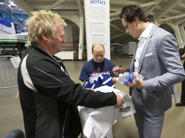 Auston Matthews of the Toronto Maple Leafs (R) signs a jersey for Matt Bradley following a pre-game skate at SaskTel Centre before facing the Ottawa Senators, October 4, 2016.