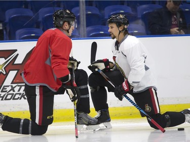 Dion Phaneuf (L) and Erik Karlsson of the NHL Ottawa Senators stretch during a pre-game skate at SaskTel Centre before an evening game against the Toronto Maple Leafs, October 4, 2016.