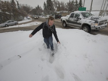 Matthew Grierson trudges through what should be a sidewalk on 108th Street at Circle Drive as he makes his way towards the university, October 6, 2016. More snow slows pedestrians and traffic.