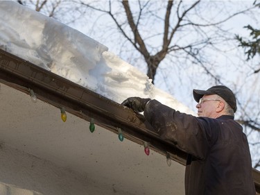 Cliff Portas of Alberta wasn't hanging lights but battling a large drift on the roof, October 12, 2016 to help a family member with cleaning the leaves from eaves troughs after an early storm dump of the white stuff last week which caught many early.