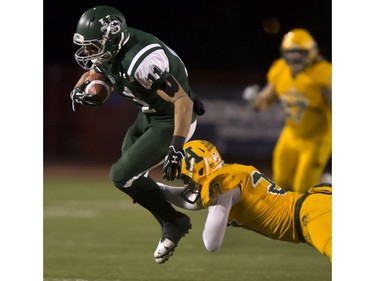 U of S Huskies' Chad Braun tries to avoid a shoestring tackle by University of Alberta Golden Bears' Tak Landry during CIS football action at Griffiths Stadium in Saskatoon, October 28, 2016.