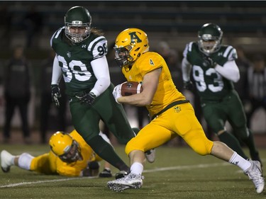 University of Alberta Golden Bears' Ed Ilnicki works to outrun U of S Huskies' Matt Kozun and Brayden Twarynski during CIS football action at Griffiths Stadium in Saskatoon, October 28, 2016.