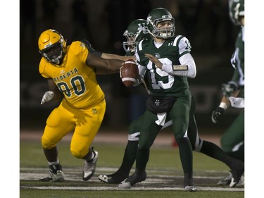 University of Alberta Golden Bears' Lucky Daniels closes in on U of S Huskies quarterback Kyle Siemens during CIS football action at Griffiths Stadium in Saskatoon, October 28, 2016.