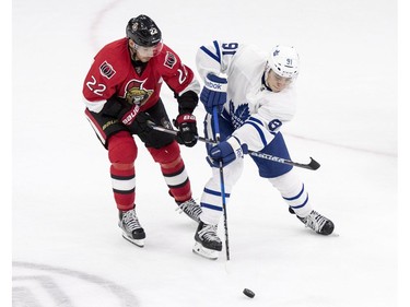 Ottawa Senators centre Chris Kelly and Toronto Maple Leafs' Trevor Moore battle for the puck during the third period of an NHL pre-season hockey game in Saskatoon, October 4, 2016.