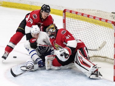 Ottawa Senators goalie Craig Anderson and Ottawa defenceman Mark Borowiecki tie up Toronto Maple Leafs forward Zach Hyman during the third period of an NHL pre-season hockey game in Saskatoon, October 4, 2016.