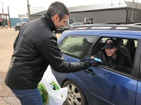 A volunteer with Saskatoon's Random Act of Kindness Day hands out a new pair of gloves to a local resident.