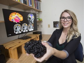 Chelsea Ekstrand holds a 3D model of her own brain.