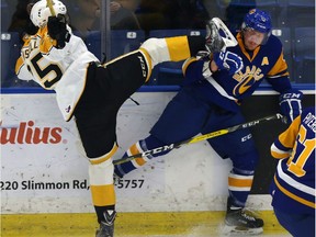 Zach Russell of the Brandon Wheat Kings gets the skate up on Bryton Sayers of the Saskatoon Blades during a hit on the boards in WHL action at SaskTel Centre on Nov. 25, 2016.