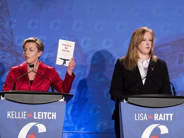 Conservative leadership candidate Kellie Leitch (L) speaks and holds up a book as Lisa Raitt listens during the Conservative leadership debate in Saskatoon, November 9, 2016.