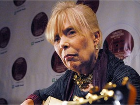 Joni Mitchell, right, plays a guitar presented to her by guitar makers Robin and Claude Boucher (not shown) at the Canadian Songwriters Hall of Fame Gala in Toronto, Sunday, January 28, 2007.