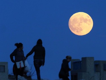 On the eve of the supermoon, visitors enjoy an unobstructed view of the spectacle as it ascends over the Lake Michigan shoreline in Milwaukee, Wisconsin, November 13, 2016. Monday's supermoon will be extra super — it will be the closest the moon comes to us in almost 69 years. And it won't happen again for another 18 years.