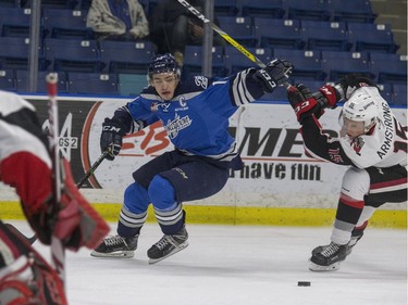 Saskatoon Blades captain Wyatt Slobosion makes his own path towards the Moose Jaw Warriors goalie, moving the stick at Brandon Armstrong out of the way in WHL first period action, November 17, 2016.