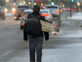 A fellow anticipates that he will be able to longboard a bit later in the day after the icy sidewalks melt from last nights rainy snow,  November 22, 2016. (GordWaldner/Saskatoon StarPhoenix)