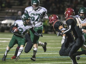 Holy Cross Crusaders running back #34 Tanner Szakacs is held up from going outside by the Centennial Chargers defence at the Saskatoon High School Football 4A City Final, November 4, 2016.