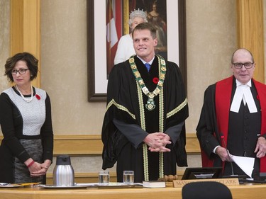 Saskatoon's new mayor Charlie Clark with city clerk Joanne Sproule and The Honourable Justice R. Shawn Smith (R) Court of Queen's Bench stand during applause after the newly elected mayor and city councillors were sworn in, October 31, 2016.