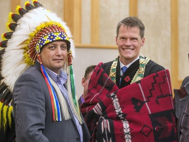 Saskatoon's new mayor Charlie Clark was draped with a blanket by Vice Chief Mark Arcand (L) after the completion of the swearing in ceremony, October 31, 2016.