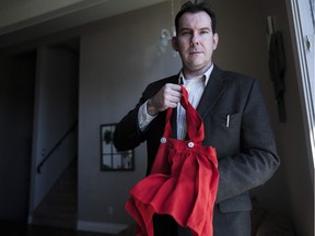 Thom Cholowski holds up a dress that is believed to be made from a Nazi flag in his home in Saskatoon, Saskatchewan on Saturday, November 5th, 2016. (Kayle Neis/Saskatoon StarPhoenix)