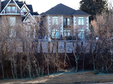 A retaining wall, which is in place to fix a collapsed patch of road along Saskatchewan Crescent, is seen through the trees from the west side of the South Saskatchewan River in Saskatoon on November 15, 2016.