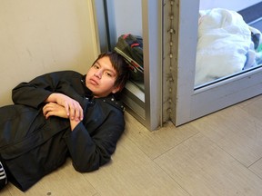 Nathan Tommy Bauchay warms up on the floor in the doorway of the Lighthouse after spending the night outside in Saskatoon on Nov. 15, 2016.