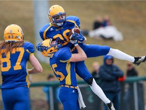 Saskatoon Hilltops' Ryan Turple picks up Rylan Kleiter after he scored a touchdown during the Prairie Football Conference championship game against the Calgary Colts at SMF field in Saskatoon. (Michelle Berg / The StarPhoenix)
