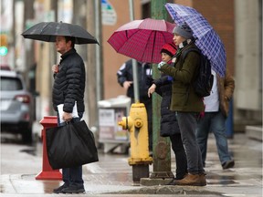 People cover up from the rain downtown, Tuesday, November 01, 2016.