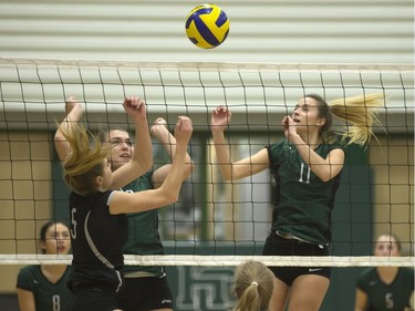 Teryn Bristow of St. Joseph Guardians hits the ball into the block of Holy Cross Crusaders Caitlin Chilliak and Ana Deacon in the city final at Holy Cross High School, November 9, 2016.