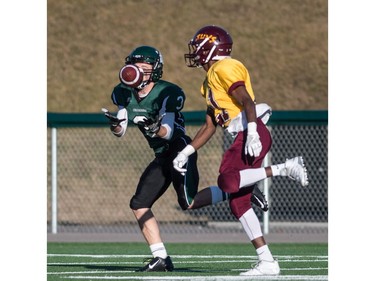 Holy Cross Crusaders receiver Michael Letts grabs a pass that was tipped by LeBoldus Golden Suns defensive back Mugisha Asharuf during the high school football 4A provincial final at SMS field in Saskatoon, November 12, 2016.