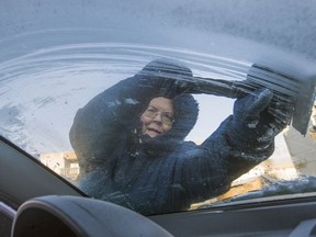 Sandra Johnson scrapes thew window of her car while warming it up in the Holiday park area after an overnight frost, Thursday, November 17, 2016.