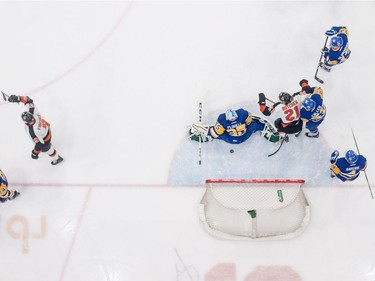 The Medicine Hat Tigers celebrate a goal on Saskatoon Blades defenceman Libor Hajek during first period WHL action in Saskatoon, November 26, 2016.