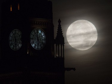 The moon is seen setting behind the Parliament buildings in Ottawa, November 14, 2016. Monday's pedigree moon, also known as a Beaver moon or Frost moon, will be the closest full moon since 1948.