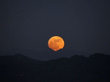 The moon rises behind the mountain range seen from Naypyitaw, Myanmar, November 14, 2016. The brightest moon in almost 69 years lights up the sky in a treat for star watchers around the globe. The phenomenon is known as the supermoon.