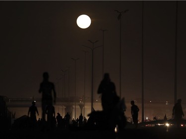 The moon rises over Shiite pilgrims as they march to Karbala for the Arbaeen ritual in Baghdad, Iraq, November 14, 2016. The brightest moon in almost 69 years lit up the sky, during its closest approach to earth as the "supermoon" reached its most luminescent phase. The moon won't be this close again until 2034.