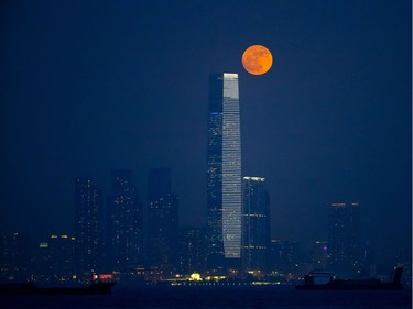 The moon rises over Victoria Habour in Hong Kong, November 14, 2016. The brightest moon in almost 69 years lights up the sky this week in a treat for star watchers around the globe. The phenomenon is known as the supermoon. The tall building is the International Commerce Centre.