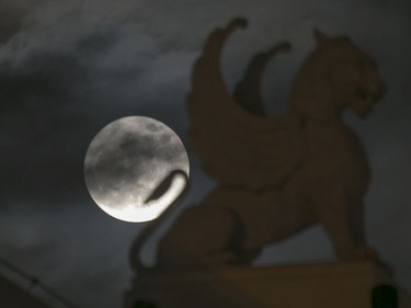 The supermoon appears behind a statue on the roof of the Opera House in Hanoi, Vietnam, November 14, 2016. The brightest moon in almost 69 years lights up the sky this week in a treat for star watchers around the globe.