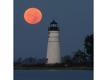 The supermoon sets behind the Madisonville, Louisiana lighthouse, November 14, 2016. The brightest moon in almost 69 years lights up the sky on Monday in a treat for star watchers around the globe. The phenomenon is known as the supermoon.