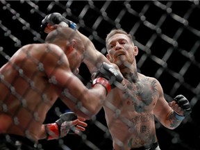 Conor McGregor (left) punches Eddie Alvarez in their UFC lightweight championship fight during UFC 205 at Madison Square Garden on Nov. 12, 2016 in New York City.