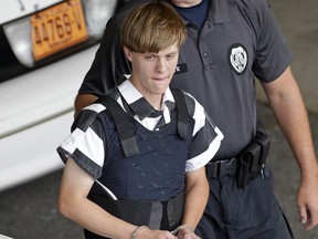 FILE - In this June 18, 2015 file photo, Charleston, S.C., shooting suspect Dylann Storm Roof is escorted from the Cleveland County Courthouse in Shelby, N.C. Prosecutors who wanted to show that Roof was a cruel, angry racist simply used his own words at his death penalty trial on charges he killed nine black people in June 2015 at a Charleston church. Roof's two-hour videotaped confession less than a day after the shooting and a handwritten journal found in his car when he was arrested were introduced into evidence Friday, Dec. 9, 2016.