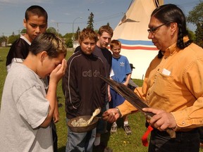 File photo of Regina student Michael Gervais wafting smoke from sweetgrass, sage and cedar from Rick Favel, an Elder's helper from the Kawawkatoose First Nation, as part of a purification ceremony.
