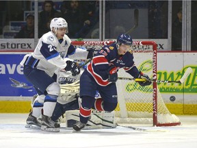 Regina Pats forward Riley Woods, 13, is closely watched by Saskatoon Blades defence Libor Hajek, 25, on a rebound during a game held at the Brandt Centre in Regina.