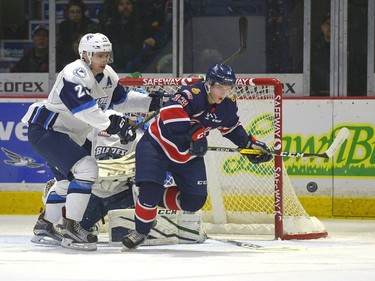 Regina Pats forward #13 Riley Woods is closely watched by Saskatoon Blades defenceman #25 Libor Hajek on a rebound during a game at the Brandt Centre in Regina, December 10, 2016.