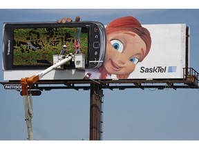 Little Red Riding Hood, a SaskTel promotions character, keeps a close eye on a pair of billboard workers on the corner of Albert St. and Saskatchewan Dr. on Wednesday, June 29, 2011.