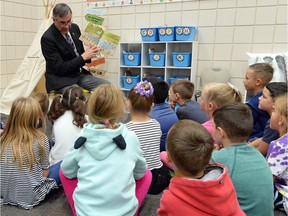 Education Minister Don Morgan reads a story to Sienna Borland's grade 1 and 2 class at W.F. Ready School in Regina.