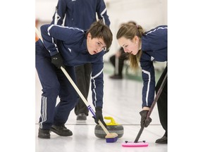 Evan Hardy Souls' lead and second Colton Jones and Katie Pepich sweep a rock to the house in the fourth end of play against the Bishop James Mahoney Saints in high school mixed curling at the Granite Curling Club, December 12, 2016.