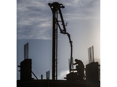 With no shield from the -30 degree cold windchill, concrete workers at the University condo construction site work on into the late afternoon, December 13, 2016.