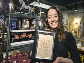 Ashley Reagan shows some of the art available at the Wanuskewin Seasonal Store.  (GORD WALDNER/Saskatoon StarPhoenix)
