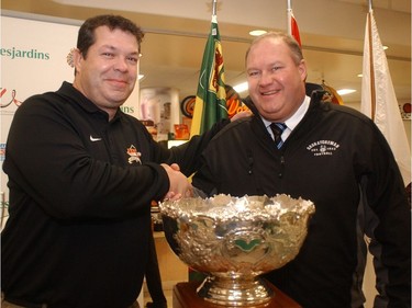 Laval's Rouge et Or head coach Glen Constantin and University of Sask. head coach, Brian Towriss shake hands in front of the Vanier Cup during a news conference at the PAC Center on campus in Saskatoon in November 2006. (Gord Waldner/Saskatoon StarPhoenix)