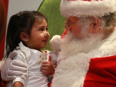 Two-and-a-half year old Ally Parrocha gives Santa the thumbs up at Lawson Heights Mall in Saskatoon on December 22, 2016.