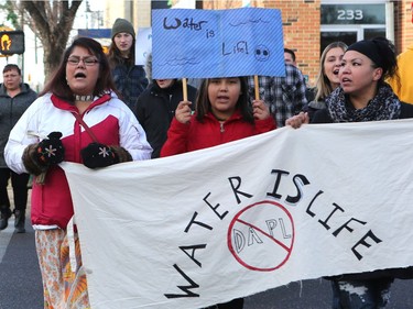 L-R: Cheryl Taniskishayinew, Jersey Machiskinic and Amanda Peequaquat walked in a group of 35 people from Midtown Plaza to the bottom of the Broadway Bridge during a Standing Rock solidarity protest in Saskatoon on December 4, 2016.
