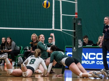 University of Saskatchewan Huskies women's volleyball libero #8 Jennifer Hueser, setter #14 Mackenzie Pek and outside hitter #7 Emily Koshinsky dig for the ball against the University of Manitoba Bisons during CIS Women's Volleyball action in Saskatoon, December 3, 2016.