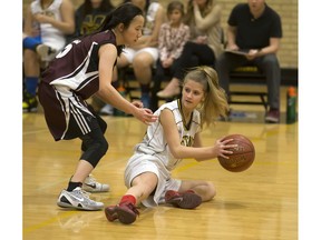 Mount Royal Mustangs' Madison Kirton looks to get rid of the ball from the ground while being guarded by Marion Graham Falcons' Elaine Hsu in high school action at Mount Royal Collegiate, December 5, 2016.